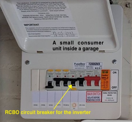 Photograph of a consumer unit annotated with an arrow pointing to the specific RCBO dedicated to the solar inverter.
