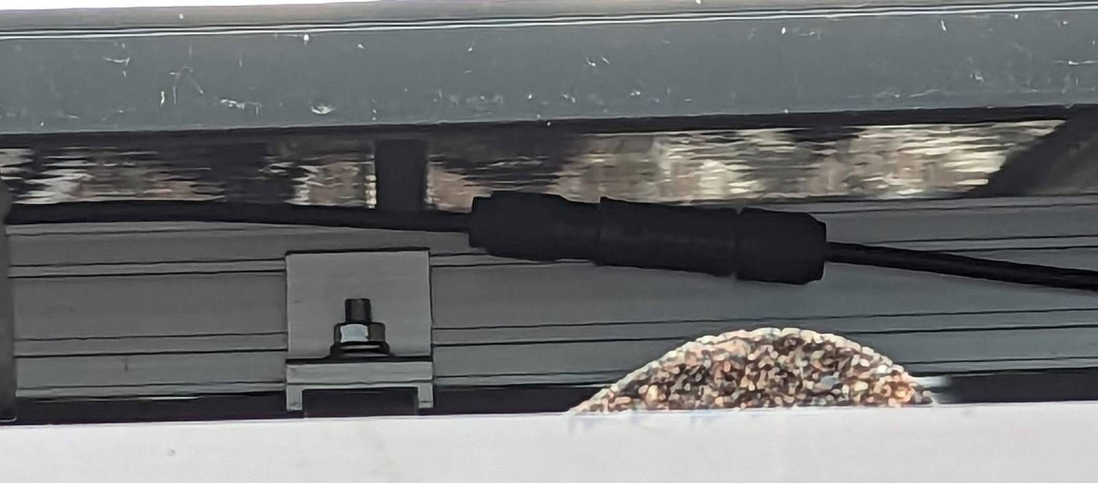 mc4 connector under a panel MC4 connector close-up under a solar panel and near a roof rail.